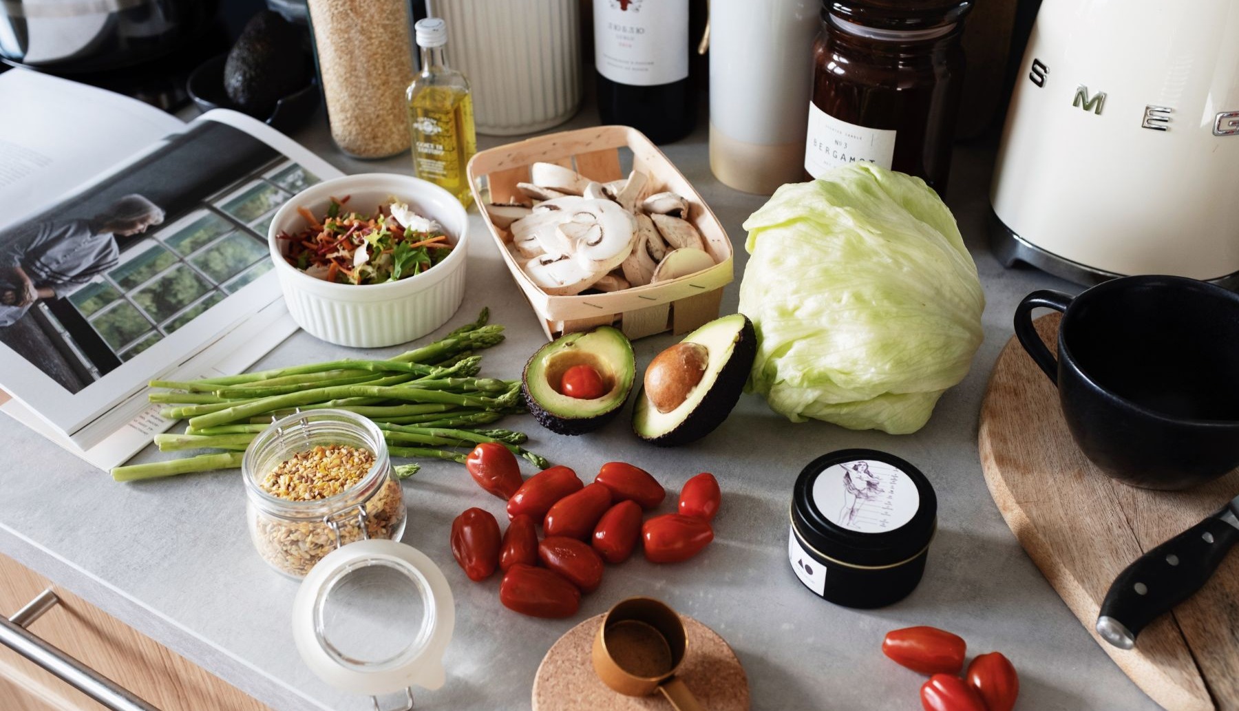 Cooking book open to recipe on kitch counter healthy whole food ingredients for recipe laid out on counter 