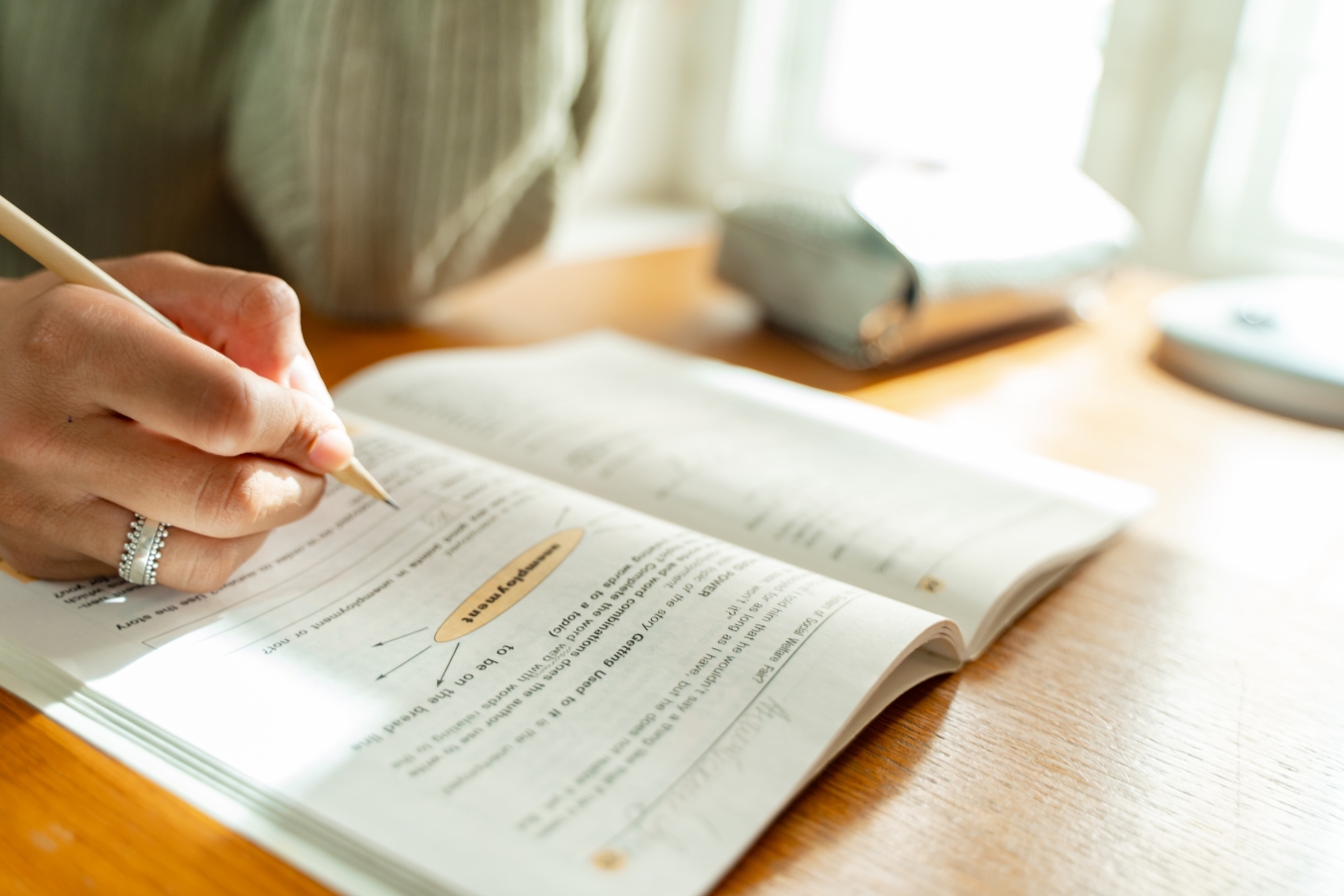 Woman sitting at table working through a intuitive eating workbook