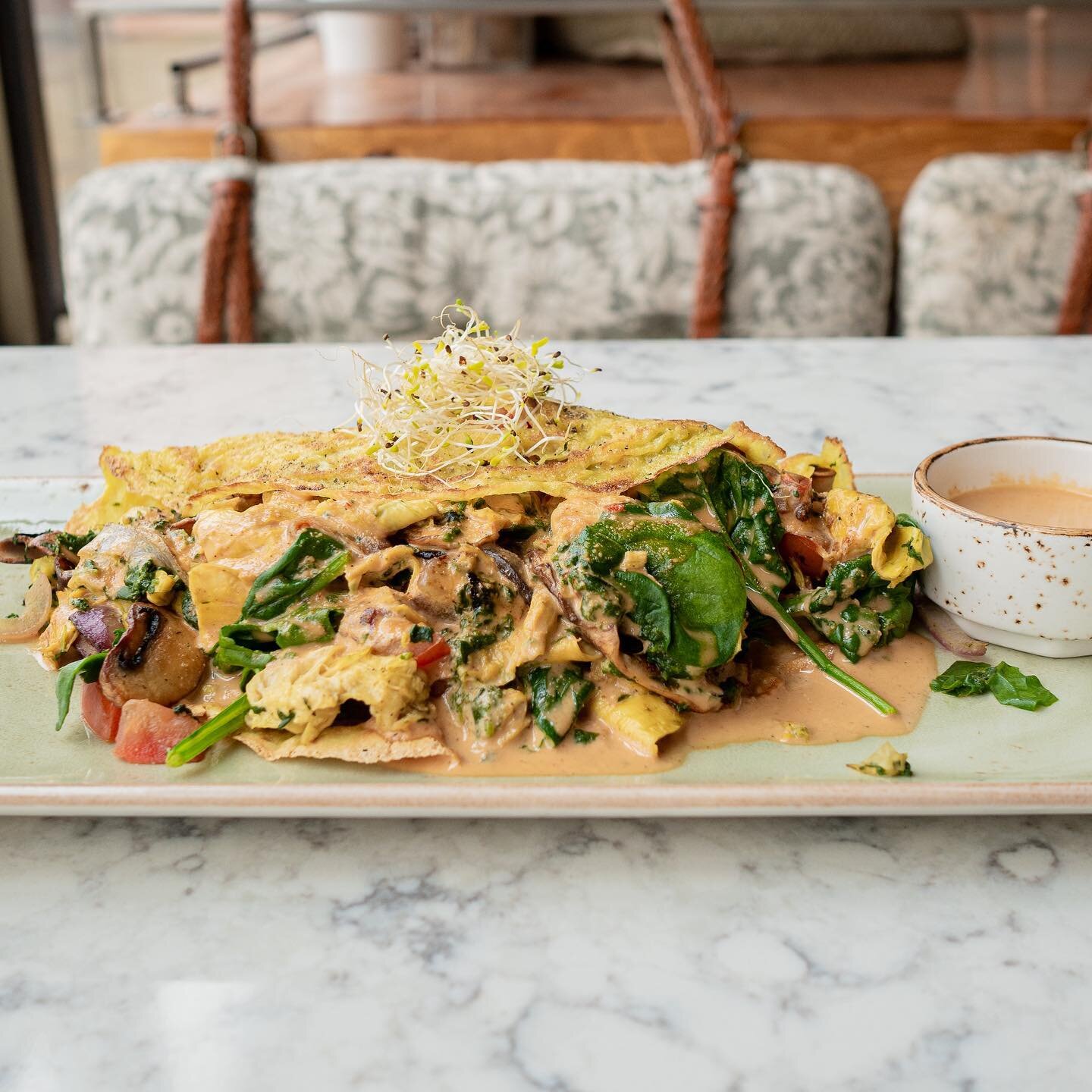 Mouth Cafe Vegan veggie packed omelette plated with micro-greens