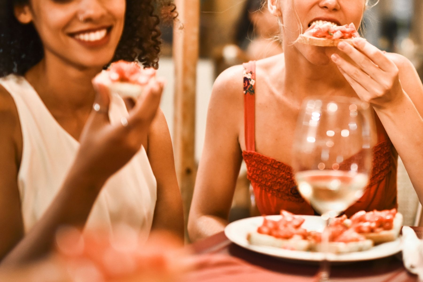 Two women eat and enjoying pizza