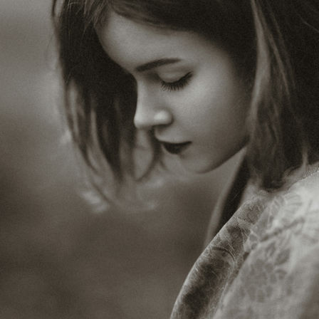 A sad woman looking down.