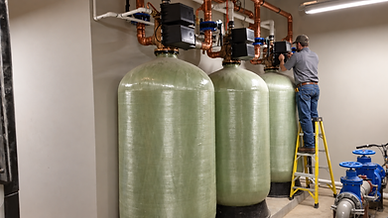 Water treatment technician servicing a commercial multi-tank water treatment system.