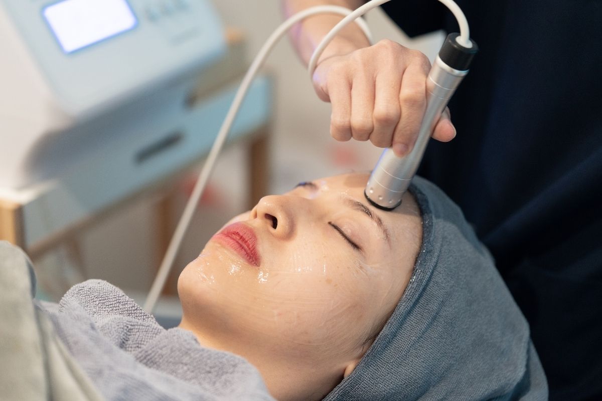 RF treatment being performed on a client’s face to tighten skin and reduce wrinkles.
