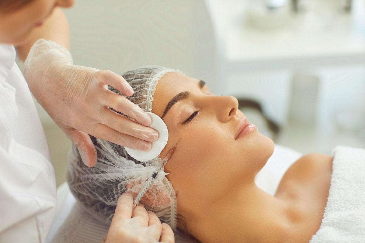 Client receiving Botox filler injections on the forehead at a professional skin clinic.