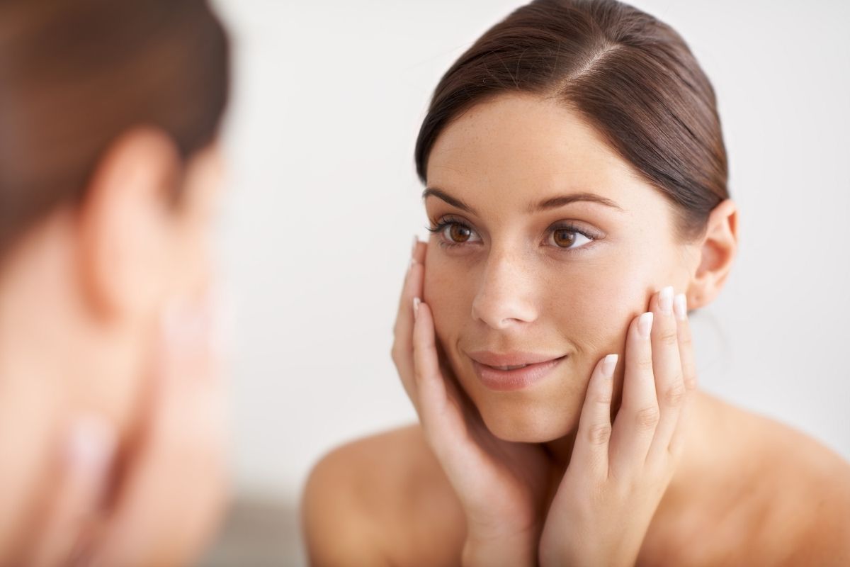 A client smiling after receiving a glowing and hydrating booster treatment.