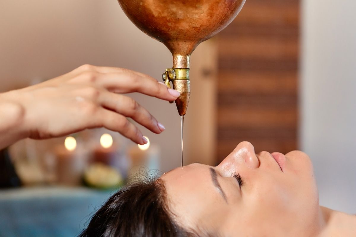 A person enjoying Shirodhara therapy to calm the mind and reduce stress.