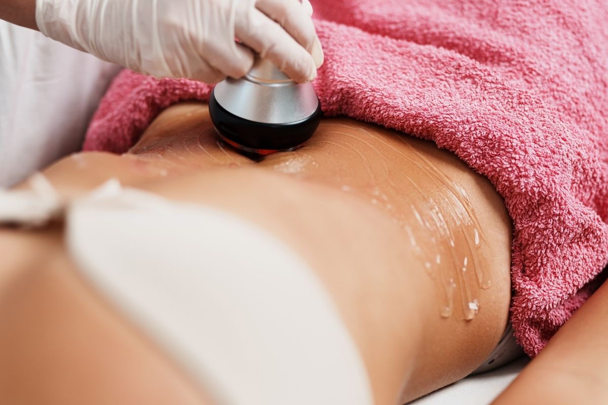 Technician using RF technology to tighten skin and contour the abdomen.