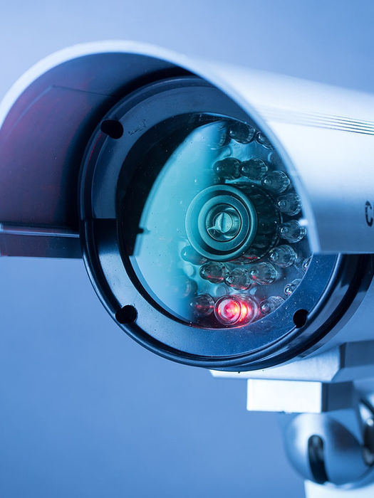CCD security camera with a glowing red indicator light.