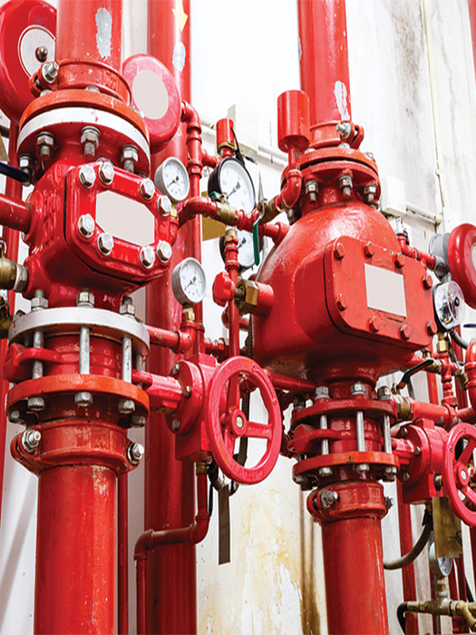 Red fire protection system pipes and valves with gauges.