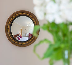 Convex mirror reflecting luxurious master bedroom