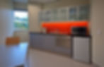 Commercial kitchen area with orange backsplash and appliances.