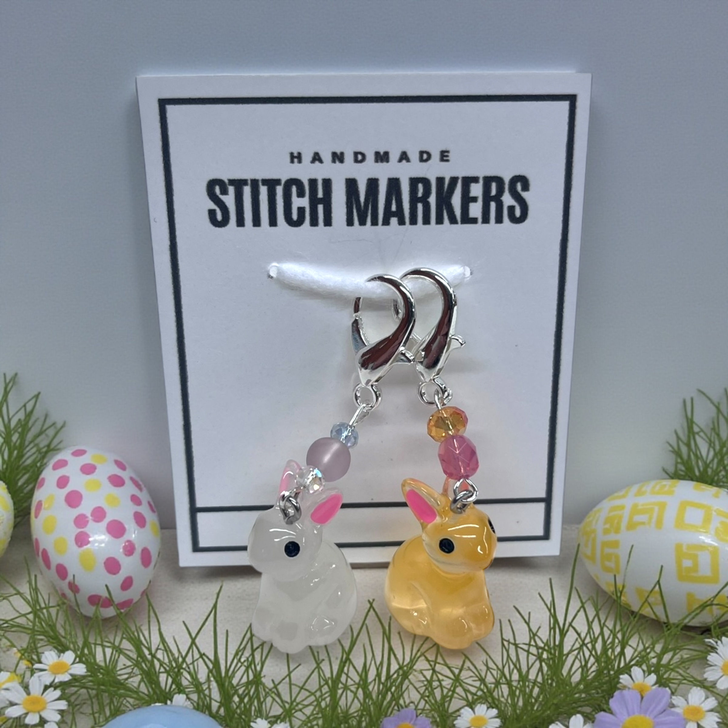 translucent bunny stitch markers for crocheting or knitting - one is white and one is orange
