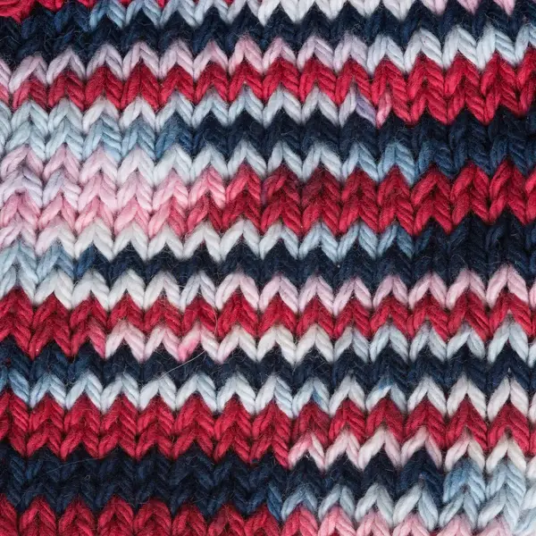 Thumbnail: lily sugar n' cream cone yarn in the colour nautical ombre, a mix of white, navy, and reds that fade to pink