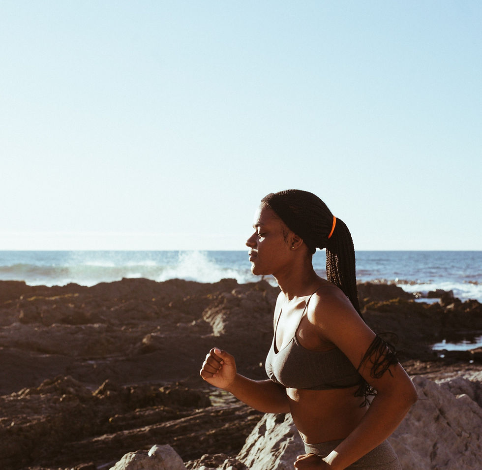 Woman running by ocean as part of her daily movement habit