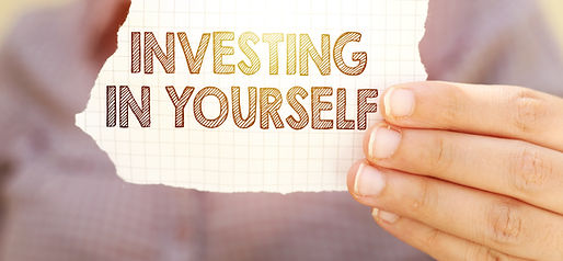 business woman holding tear paper with investing in yourself text.jpg