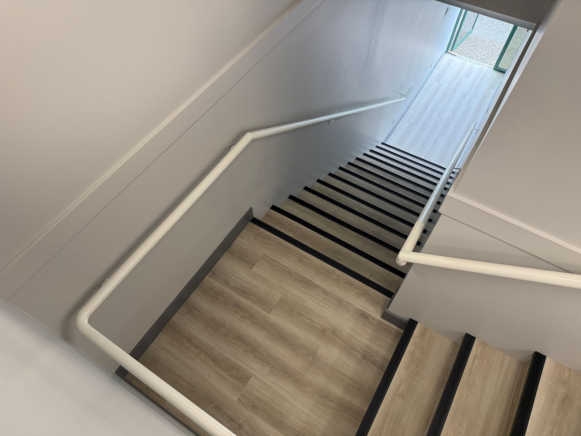 Top-down view of a clean, newly constructed office stairwell.