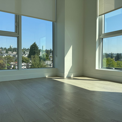 Bedroom window corner showing clear glass and tidy floor.