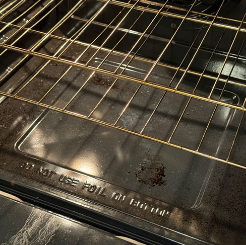 Dirty oven interior with baked-on stains before move-out cleaning.