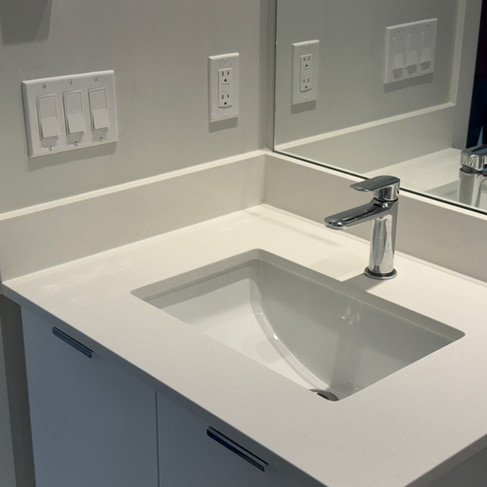 Restored vanity with bright quartz surface, shiny single-lever faucet, and spotless undermount sink.