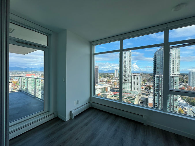 Professionally cleaned empty condo unit in Vancouver with large windows and stunning city view – move-out cleaning by OnePro Cleaning.