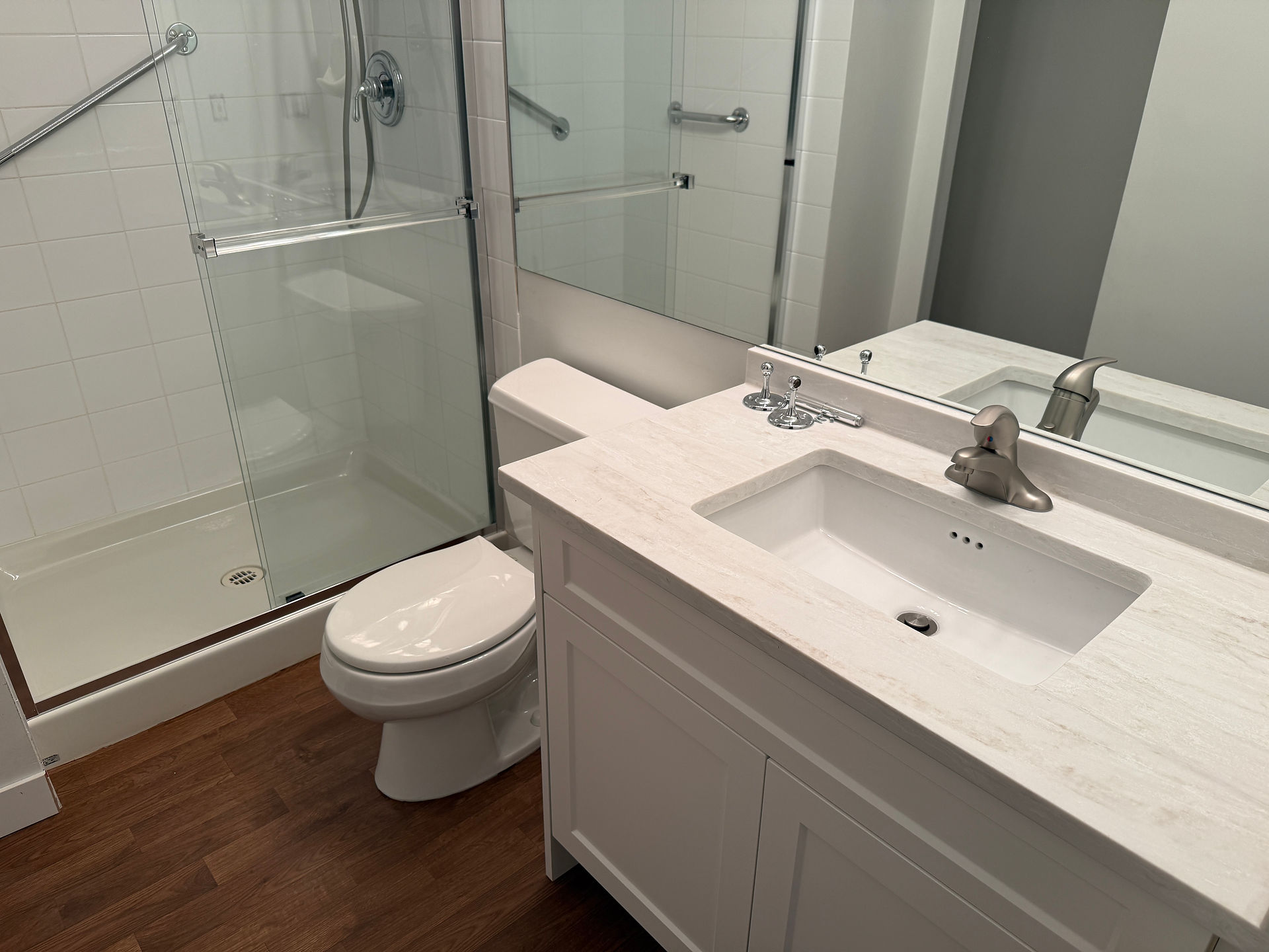 Sparkling clean modern bathroom with glass shower doors after post-construction cleanup.
