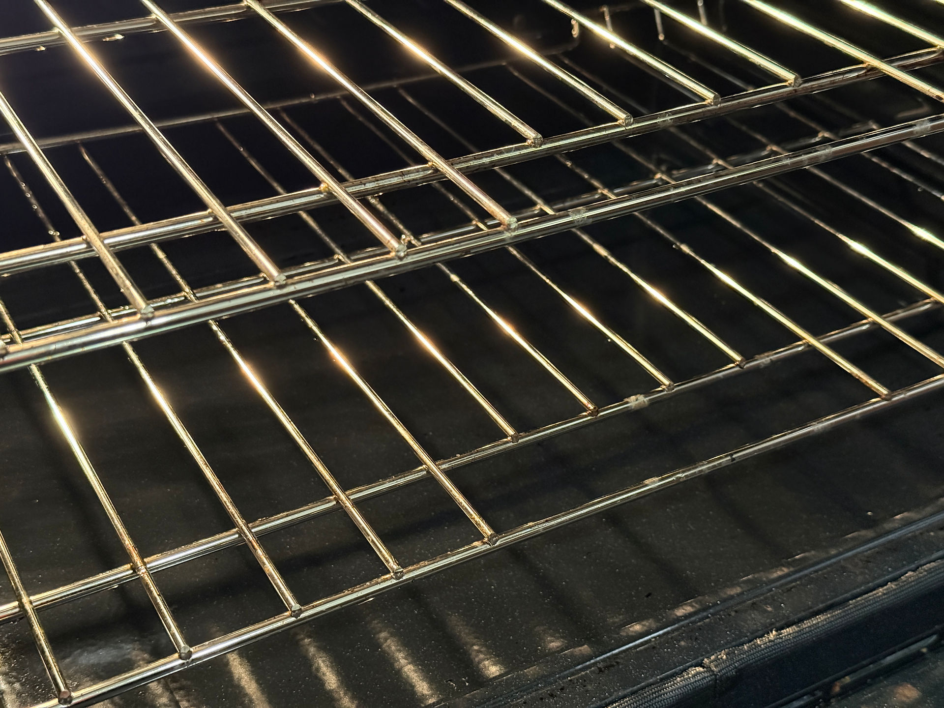 Shining clean oven interior and wire racks after an end of lease cleaning service.