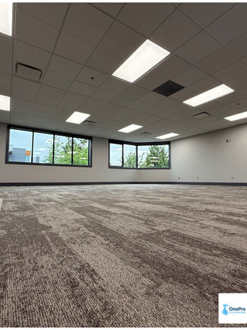A wide angle view of a completely clean, empty corporate office ready for handover after a professional post-construction cleaning.
