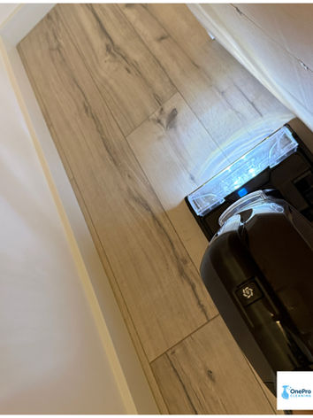 Close-up of professional floor washing equipment removing fine construction dust from hardwood