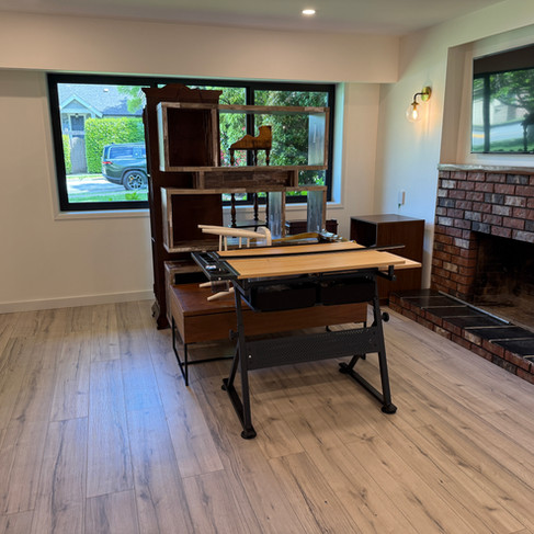 Clean living room with uncovered furniture and dust-free hardwood floors after renovation cleanup