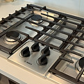 Degreased stainless steel gas cooktop and grates during kitchen deep cleaning