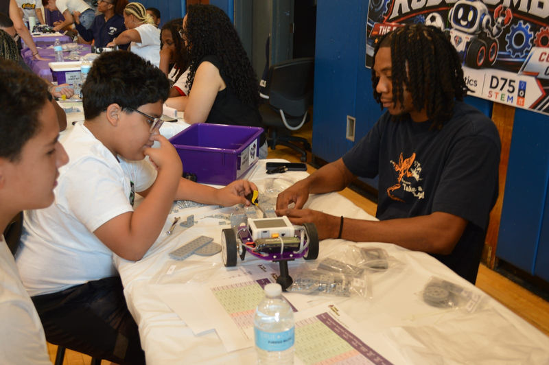 Students build their robots with True Robotics kits at the event.