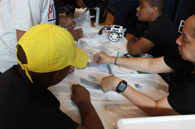 Students work together on their robot at the build table.