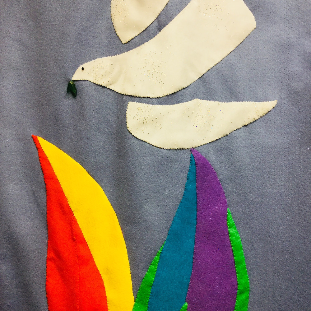 a tapestry with a dove and rainbow colours