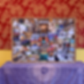 A vibrant, large vision board filled with magazine cutouts and quotes leans against a red and yellow brocade wall on a purple, tapestry-covered cabinet below