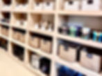 Close-up view of labeled pantry containers and baskets neatly arranged on wooden shelves