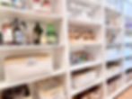 Eye-level view of a neatly arranged butler’s pantry with labeled glass jars and baskets