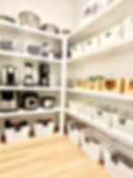 High angle view of a butler’s pantry with pull-out wire baskets and labeled jars
