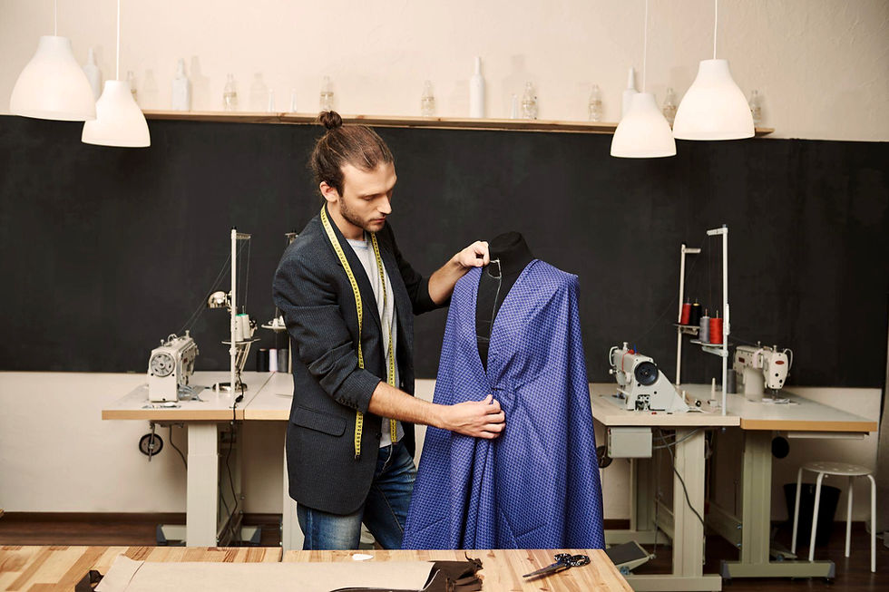 A designer meticulously evaluates a vibrant blue garment on a dress form in a modern workshop, surrounded by sewing machines and tools, showcasing his dedication to craftsmanship.