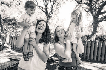 Duas mães levantam filhos nos ombros