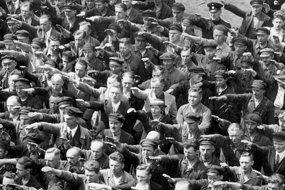 Above: August Landmesser (centre right) was the sole individual who refused to conform and hail Hitler in this image. History vindicated him for it.