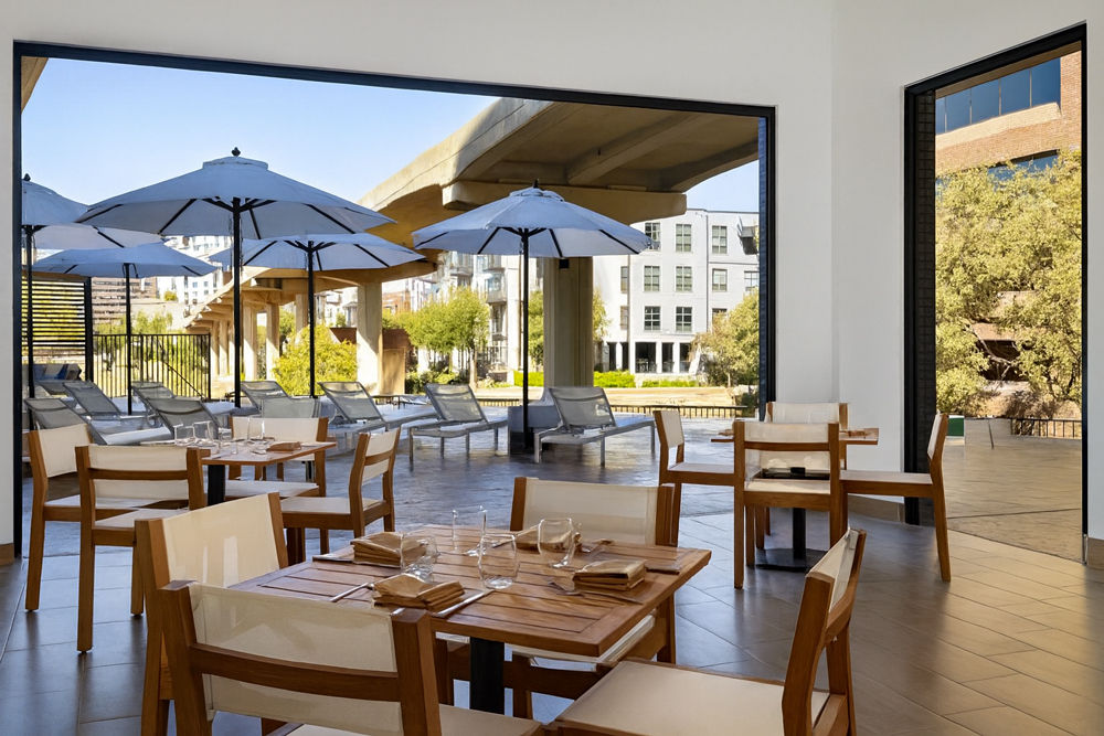 Modern commercial exterior and interior featuring large-scale glass folding doors and curtain walls by EZ FOLD A DOOR, showcasing professional architectural glazing for business environments.