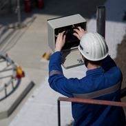 Arbeiter installiert Baustellen Kamera Zeitraffer auf einer Baustelle am Mast