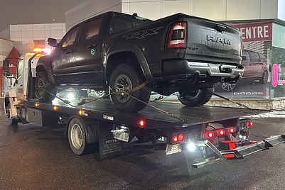 dodge ram being towed by an Xtreme Towing flatbed truck