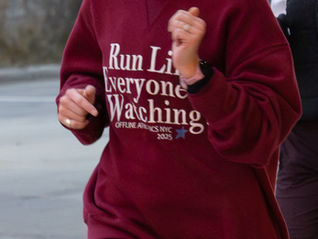 Torso of woman wearing red sweater and running.