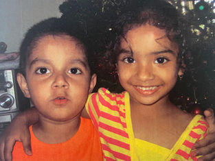 picture of a young boy wearing orange and a young girl a in pink and yellow stripped shirt.