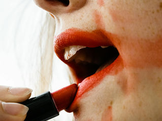lips with messy red lipstick being applied