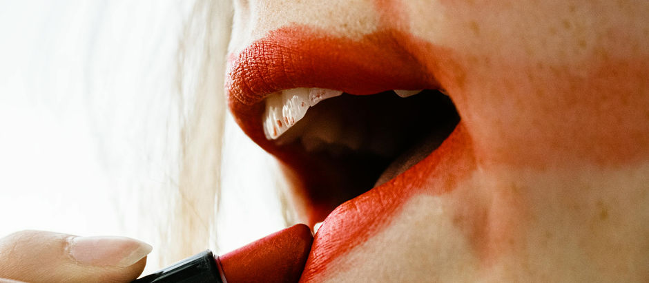 lips with messy red lipstick being applied