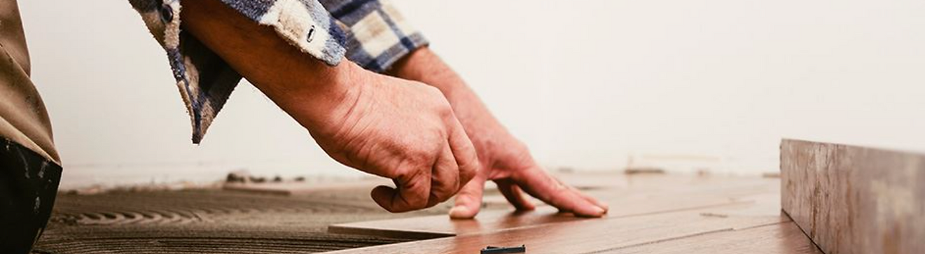 Professional installing wood floors as part of home repair or renovation.