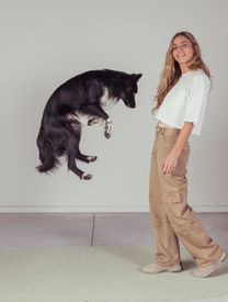 Roni and Rhythm the dog starting to jump opposite her