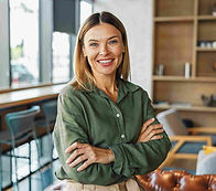 Middle-aged white women in a green shirt smiling as she looks forward.